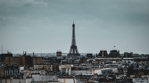 Buildings in city against cloudy sky