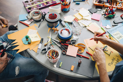 High angle view of colleagues working at table in creative office