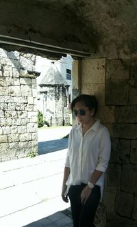 Portrait of young man standing on brick wall