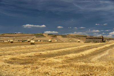 Hay bales on field against sky