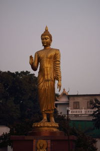 Statue against temple building against sky