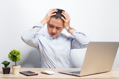 Young man using mobile phone while sitting on table