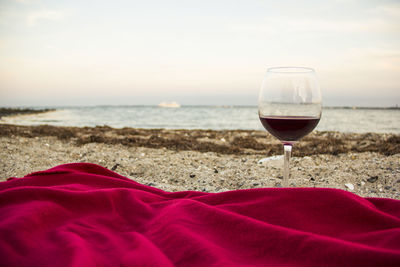 Red wine in wineglass at beach during sunset