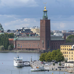 View of buildings in city against cloudy sky