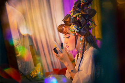 Rear view of woman holding religious equipment