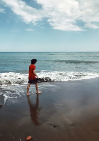 Full length of boy on beach against sky