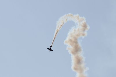 Low angle view of airplane flying against sky