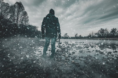 Rear view of person in snow against sky