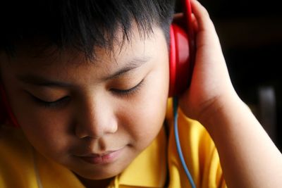 Close-up of boy listening music at home