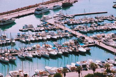 High angle view of sailboats moored at harbor against sky