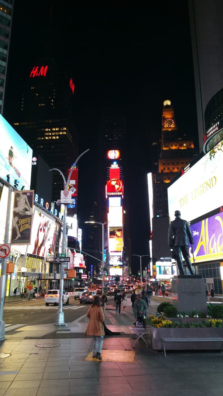 PEOPLE WALKING ON CITY STREET AT NIGHT