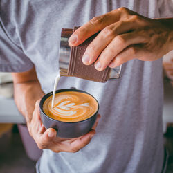 Midsection of man preparing coffee in cafe