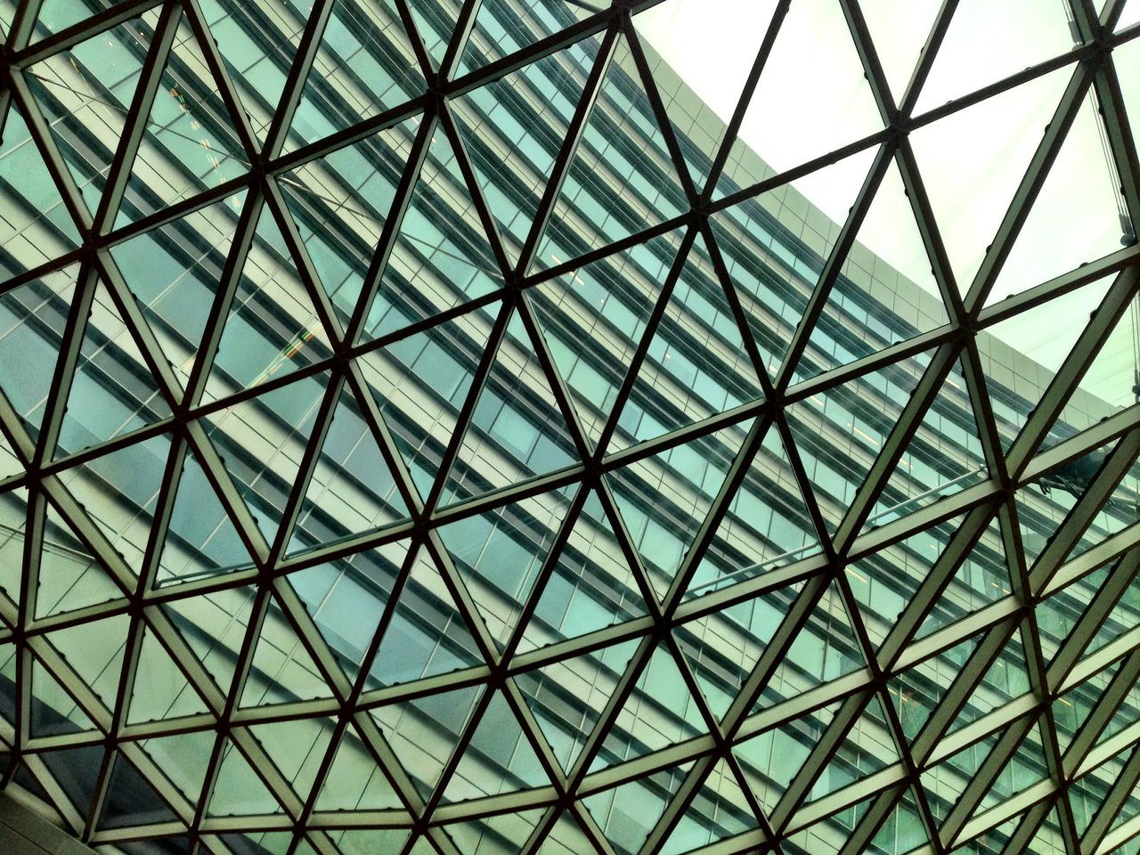 architecture, built structure, glass - material, low angle view, pattern, full frame, indoors, backgrounds, architectural feature, modern, design, ceiling, geometric shape, transparent, grid, day, no people, skylight, sky, building exterior