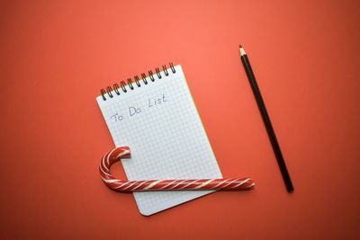 High angle view of pen on paper against orange background