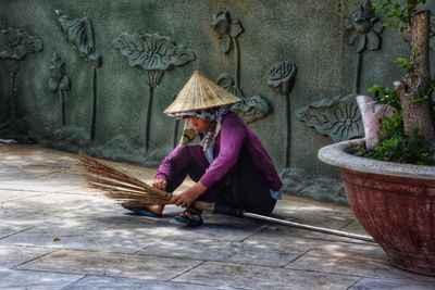 Full length of woman sitting with umbrella