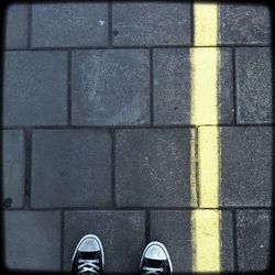 Low section of person standing on tiled floor