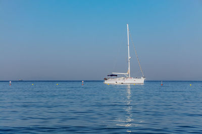 Sailboat sailing on sea against clear sky