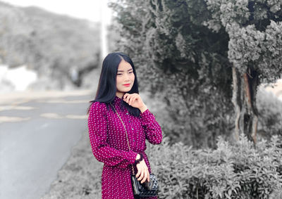 Portrait of beautiful young woman standing in park