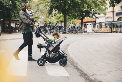 Father crossing road with son in city