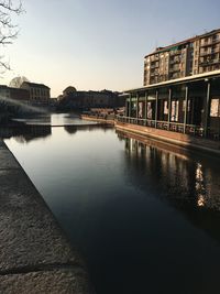 River by buildings against sky in city