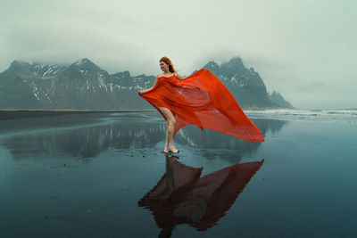 Attractive model in red dress on reynisfjara beach scenic photography