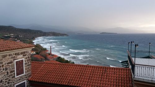 High angle view of townscape by sea against sky