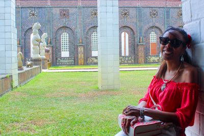 Portrait of smiling woman sitting at historic place