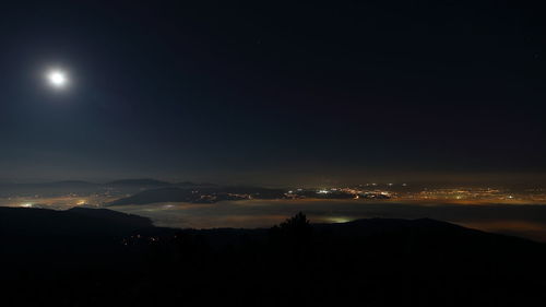 Silhouette landscape against sky at night