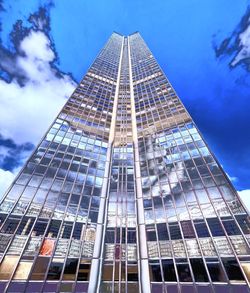 Low angle view of modern building against cloudy sky