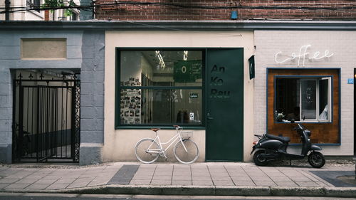 Bicycle on footpath against building in city