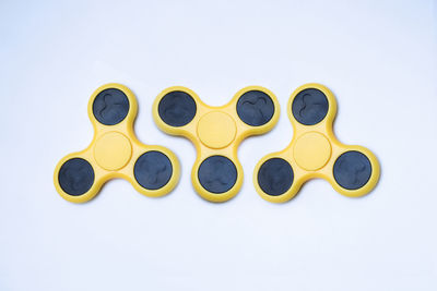 Yellow fidget spinners over white background