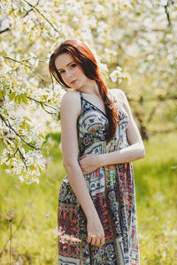 Young woman standing against plants