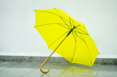 Close-up of yellow umbrella on tiled floor