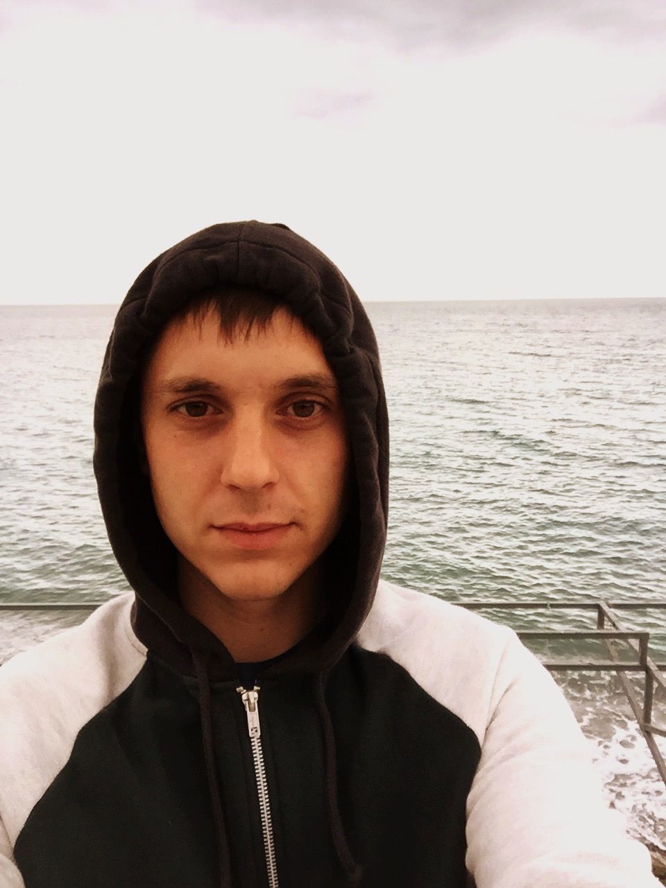 sea, water, portrait, looking at camera, headshot, lifestyles, young adult, person, beach, horizon over water, leisure activity, head and shoulders, front view, young men, standing, nature, casual clothing, tranquility