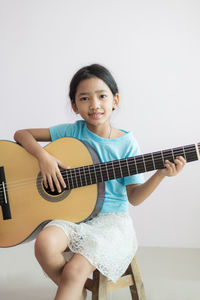 Portrait of a smiling girl playing guitar