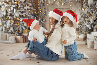 Smiling mother with kids against christmas decoration