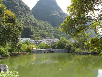 Scenic view of river by trees against sky