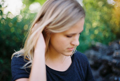 Close-up of young woman with hand in hair