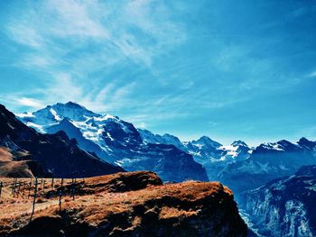 Scenic view of snowcapped mountains against blue sky