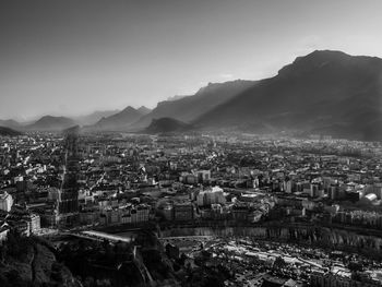 High angle view of town by mountains against clear sky