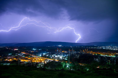 Illuminated cityscape against sky at night