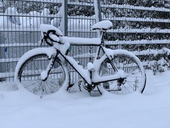 Bicycle parked on snow covered land