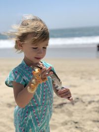 Girl holding sunglasses on beach