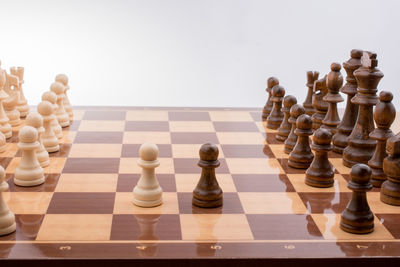 Close-up of chess pieces on board against wall