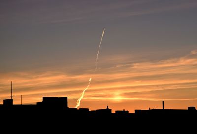 Low angle view of silhouette buildings against sky during sunset