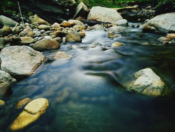 High angle view of stream flowing through rocks