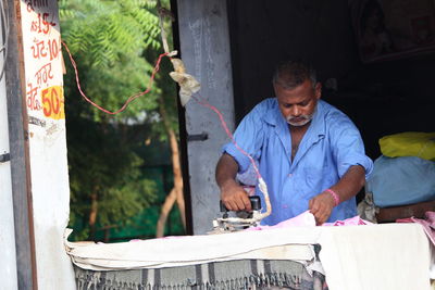 Man ironing outdoors