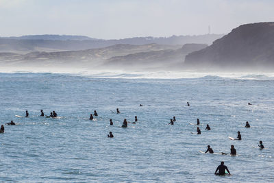 View of surfers on sea waiting for the perfect wave in baleal