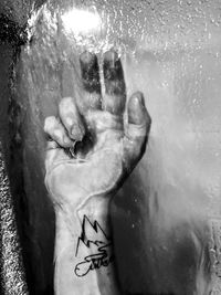 Close-up of person hand with text on wall