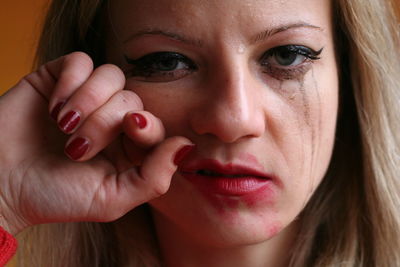 Close-up portrait of sad woman wiping tears